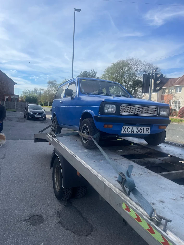 Blue classic car strapped to a flatbed