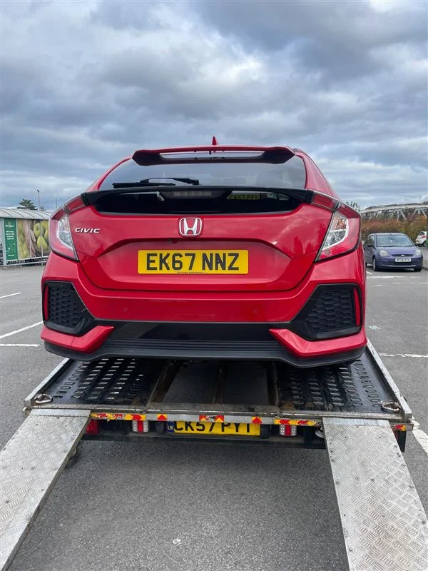 Red Honda Civic on the back of a recovery truck