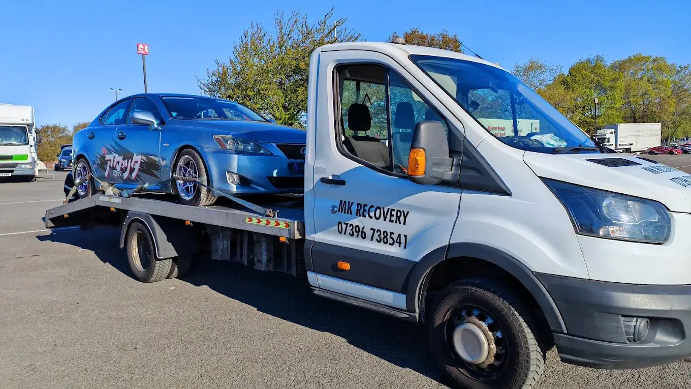 MK Recovery branded truck carrying a blue Lexus