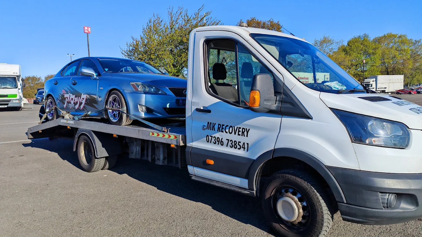 MK Recovery branded truck carrying a blue Lexus