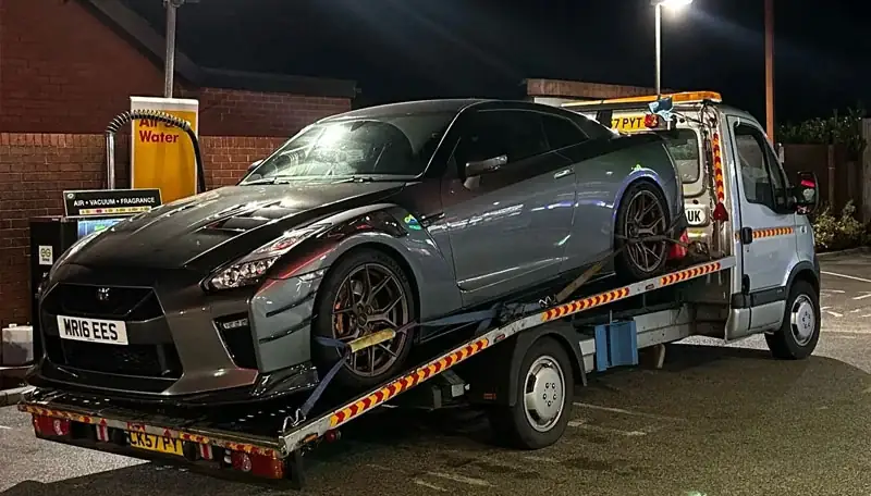 Nissan GT-R loaded on an MK Recovery flatbed at night