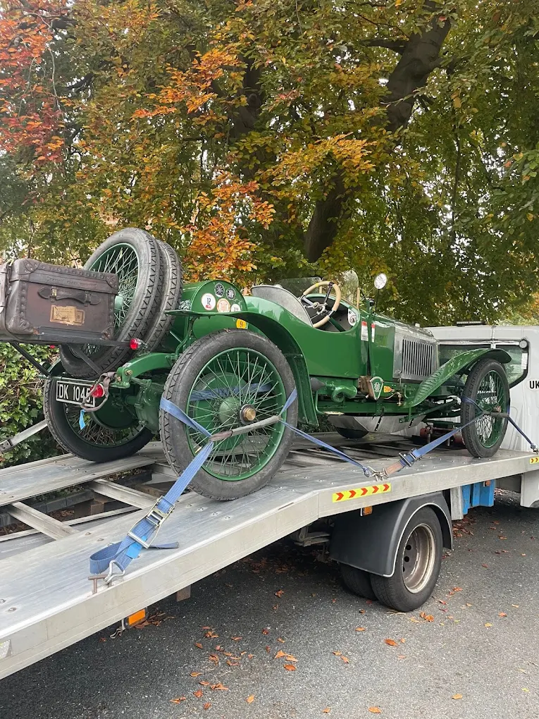 Green vintage car strapped onto an MK Recovery flatbed
